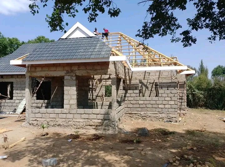 Toshe Ujenzi Works Limited building under construction with roof framing and workers